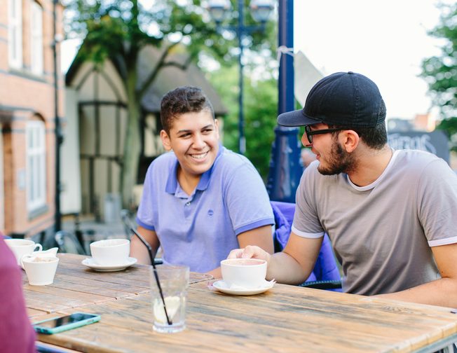 A group of students enjoying the nice weather outside and drinking coffee