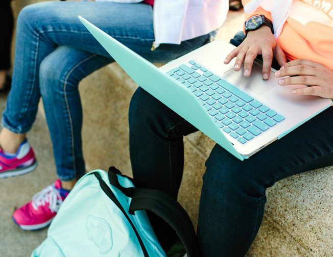 Some students sitting and working on the laptop