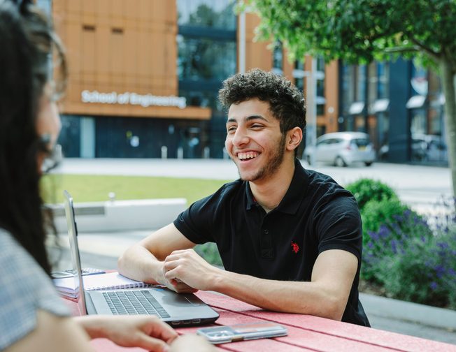 Students studying on the bench outside