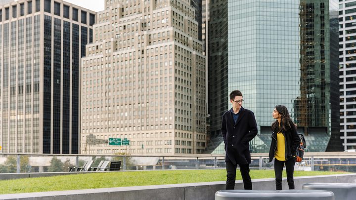 Two students walking on the water front of New York City