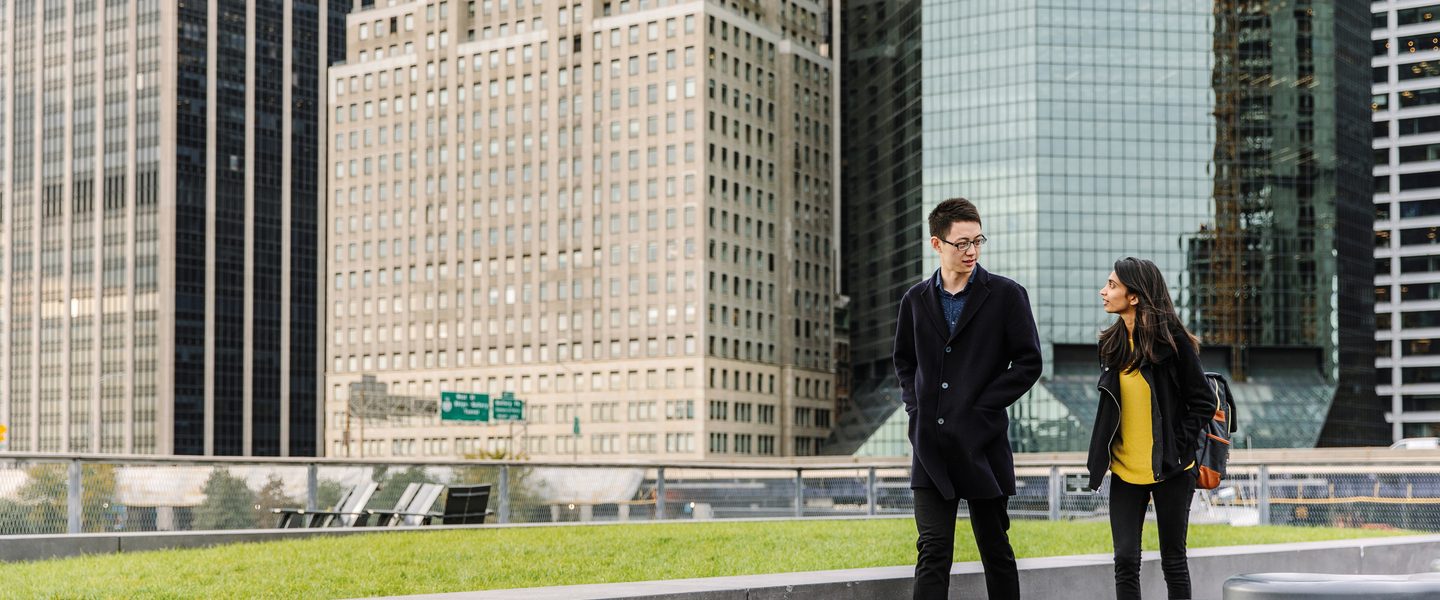 Two students walking on the water front of New York City