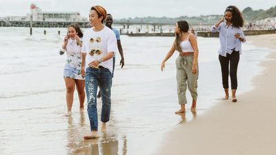 A group of students walking along the shore on Bournemouth beach