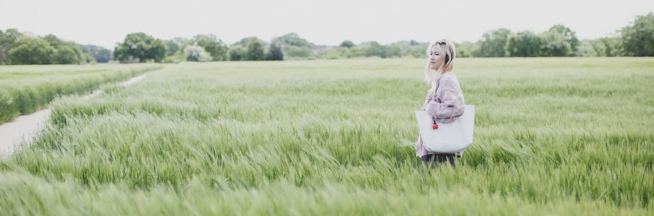 A student walking through long grass on the University of Essex campus