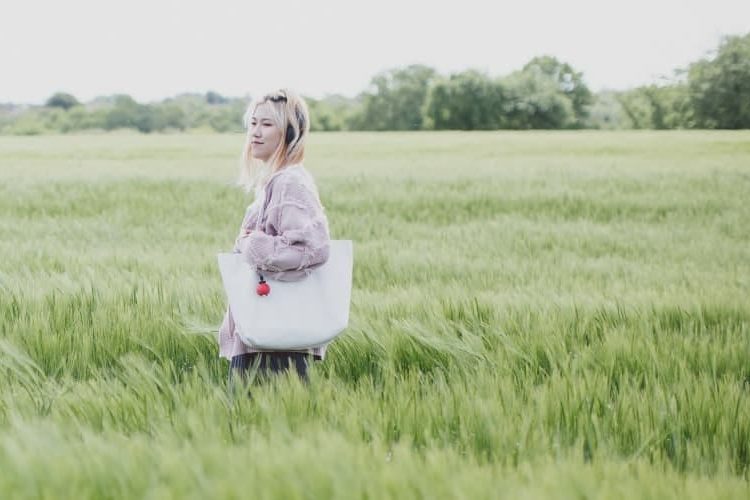 A student walking through long grass on the University of Essex campus