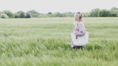 A student walking through long grass on the University of Essex campus