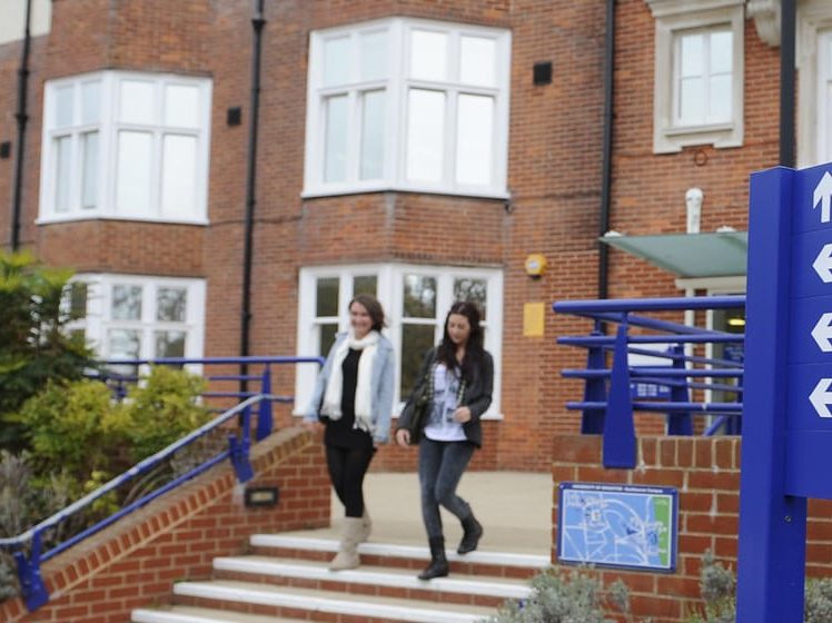 students walking out of college building