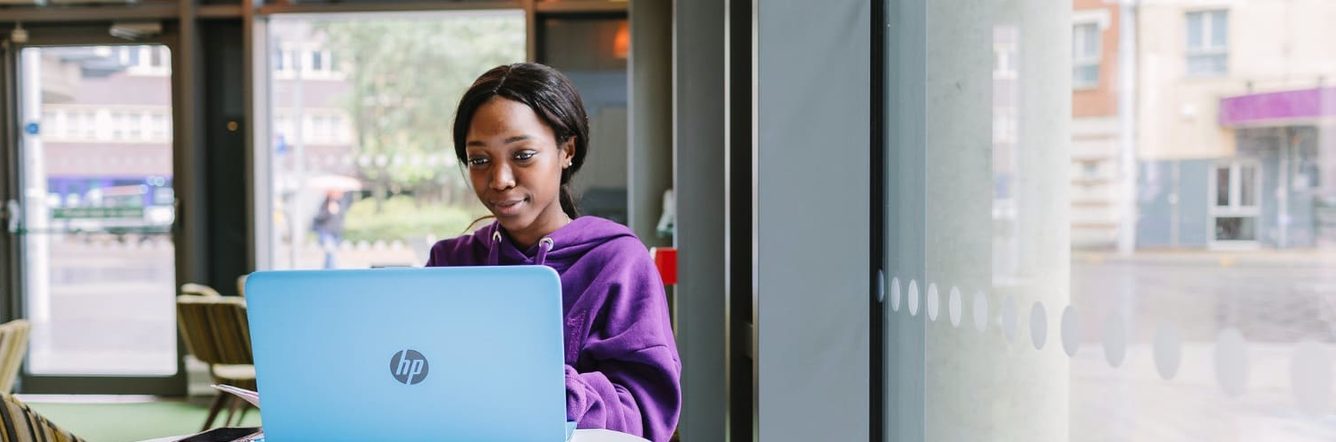 Student Ambassador Munashe sits at her laptop