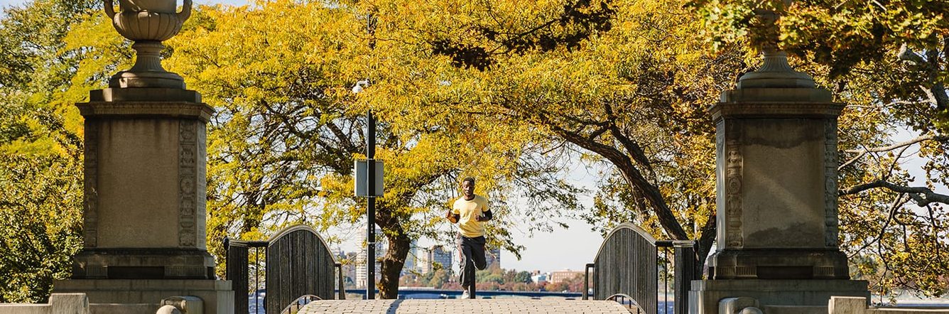 Student running under the trees