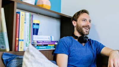 student sitting in his room with headphones