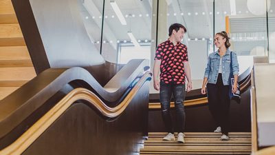 students walking down the stairs in college building