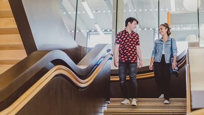 students walking down the stairs in college building