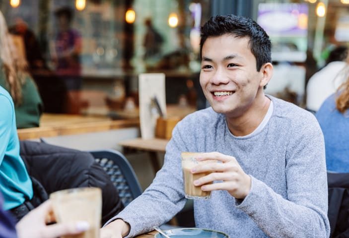 student having tea outside