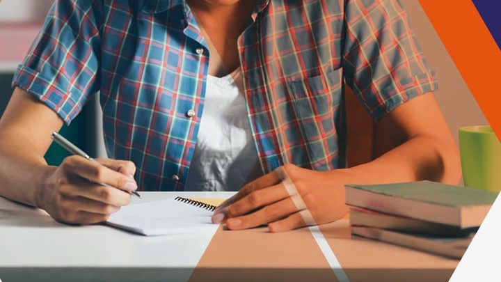 student writing on notebook