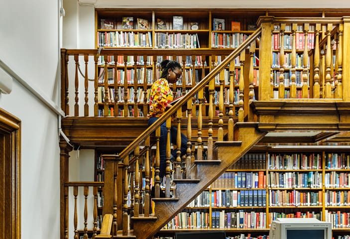 student climbing stairs in British library