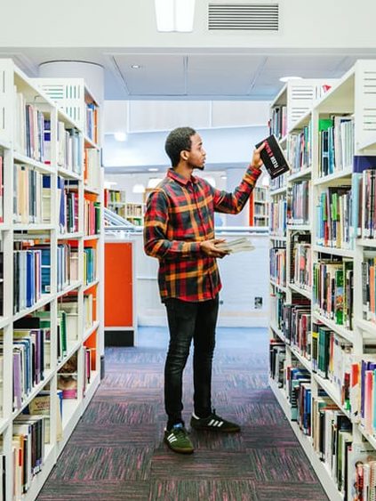 student checking books in library