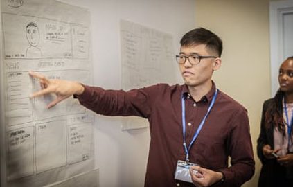 student pointing on whiteboard