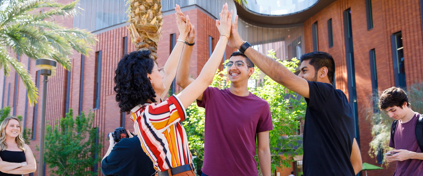 International students high five on Palm Walk