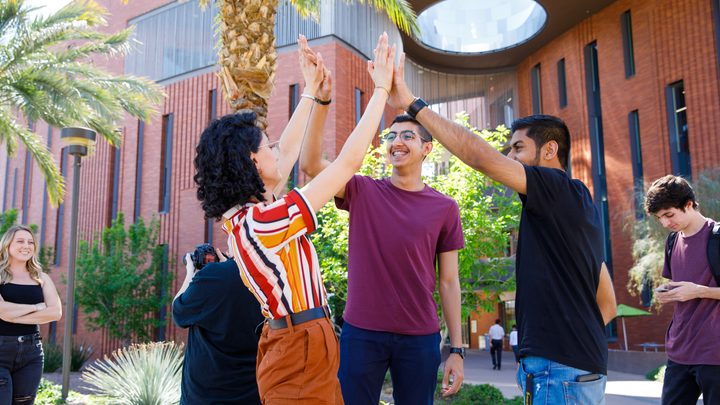 International students high five on Palm Walk