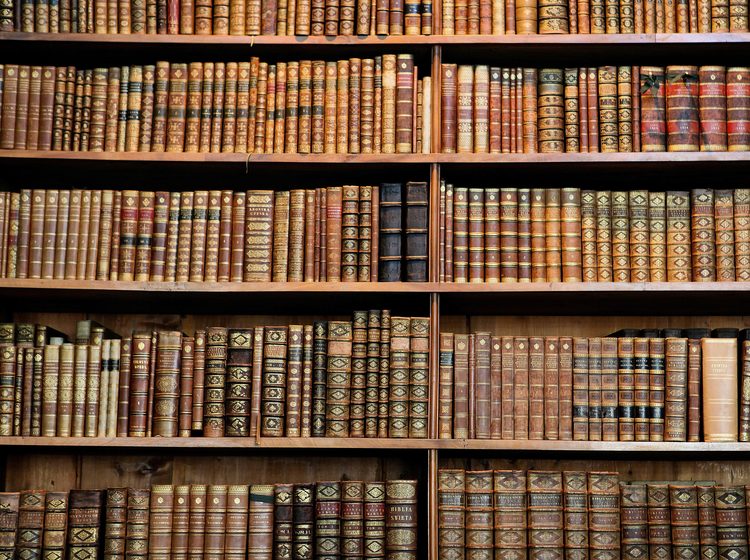 Old books stored neatly in bookshelf