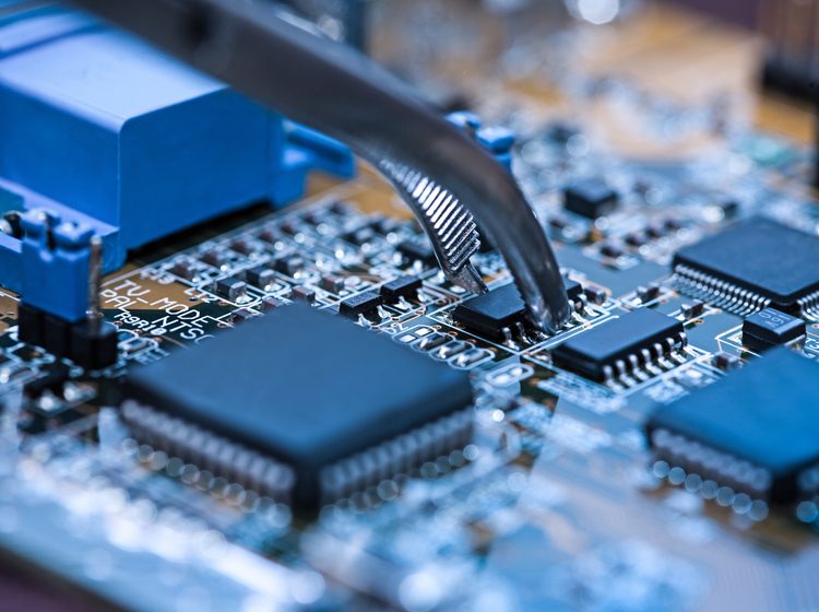 Close up of tweezers holding computer chip