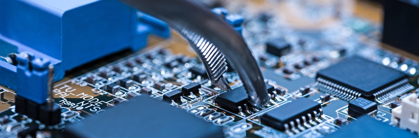 Close up of tweezers holding computer chip