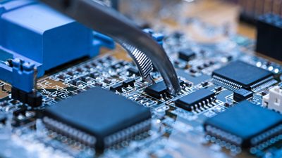 Close up of tweezers holding computer chip