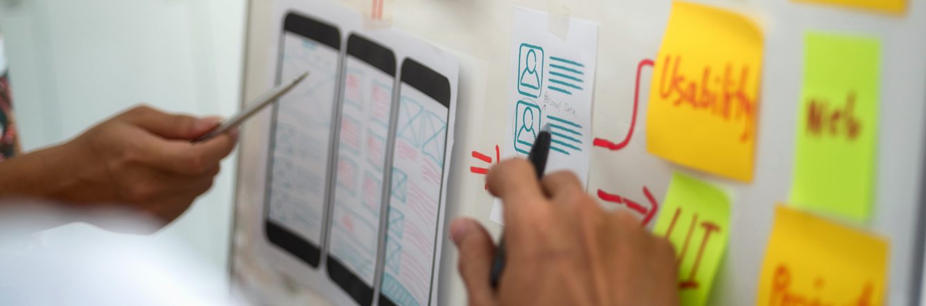 Close up of mobile app wireframe and sticky notes