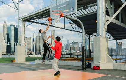 Students playing basketball in the communal basketball court