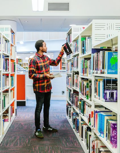 Student holding books at Nottingham Trent University library