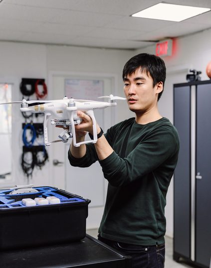 Pace university student holding a drone at the media studio