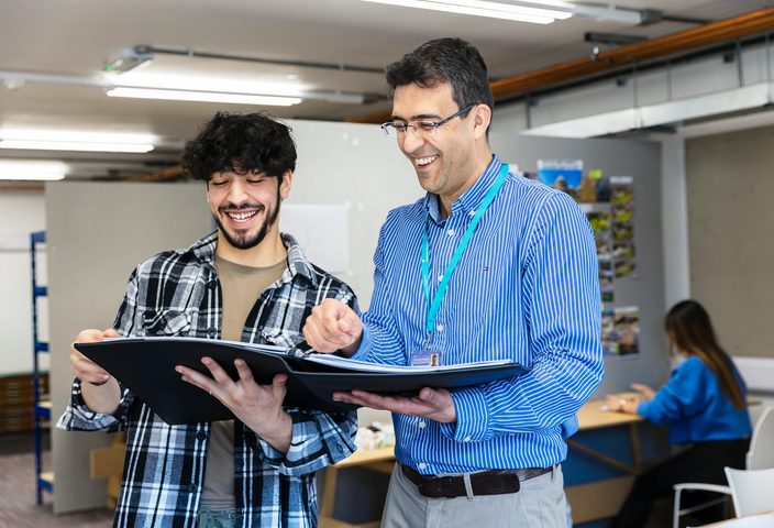 University of Brighton student and staff smiling whilst in a discussion