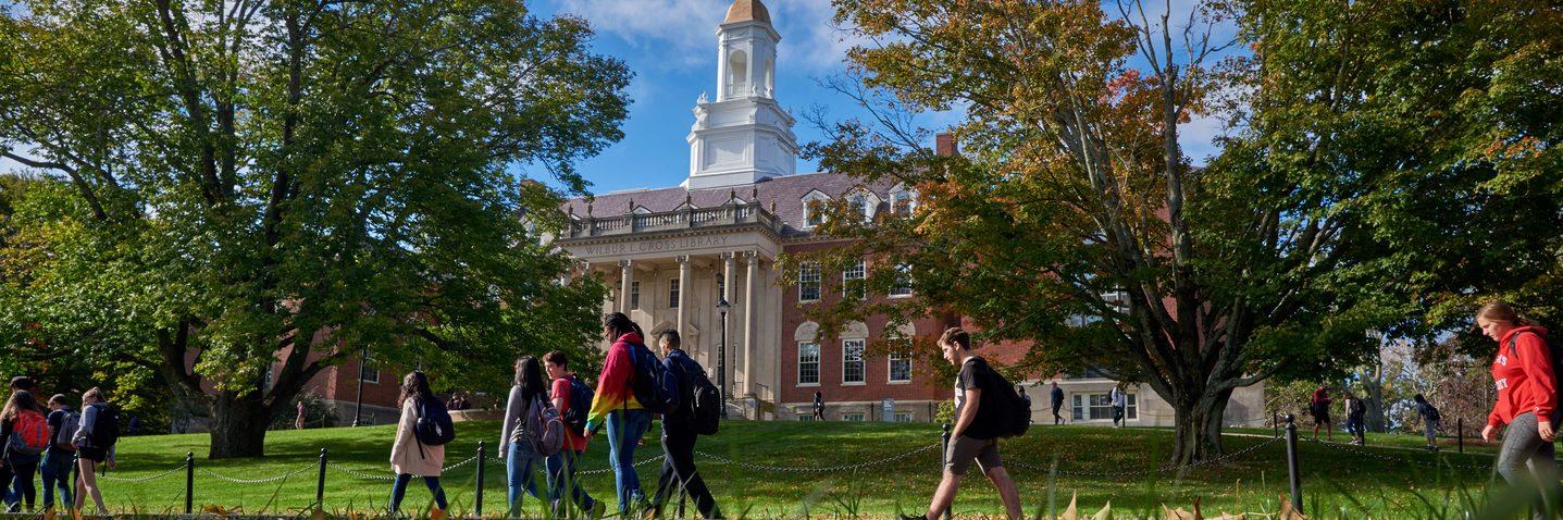 University of Connecticut students walk past the Wilbur Cross Building