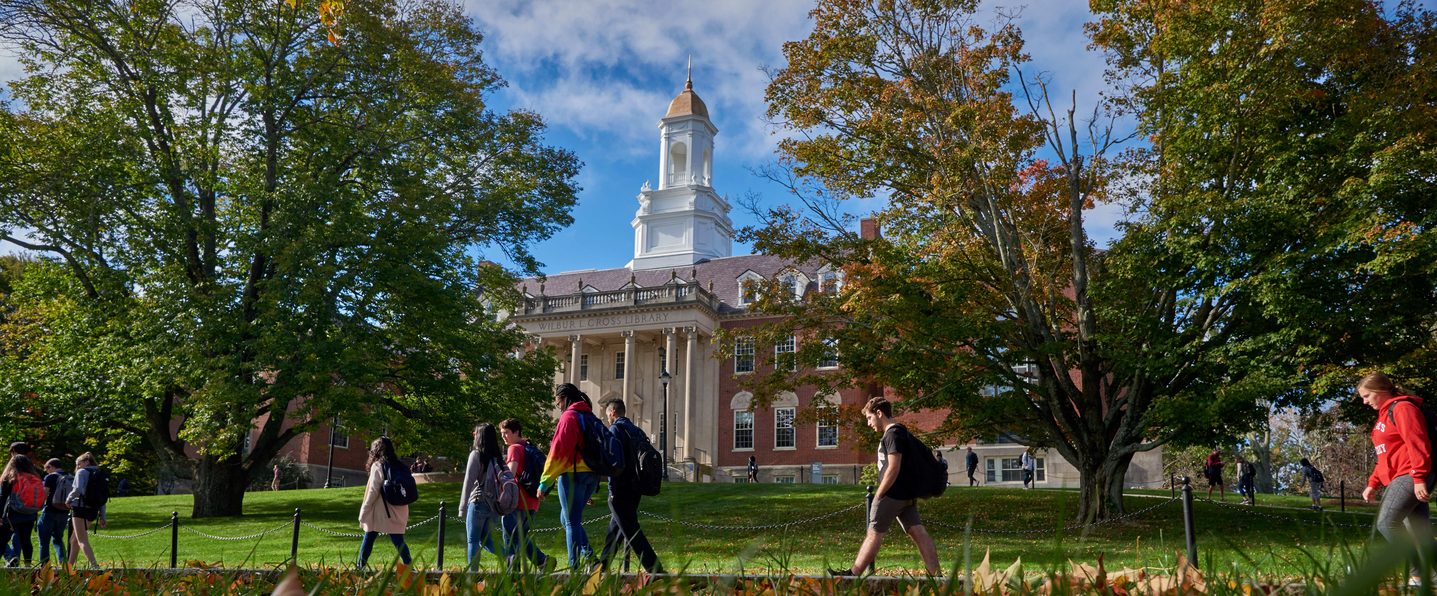 University of Connecticut students walk past the Wilbur Cross Building