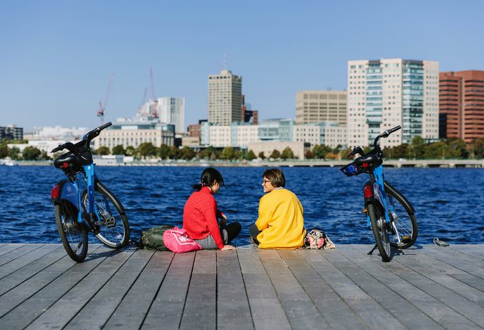 Students sitting by the bay in Boston