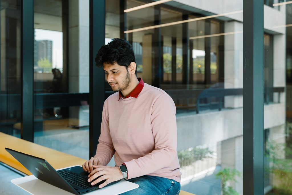 Pace University student using laptop on campus