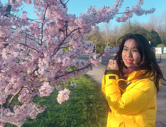 Caroline from China posing near a cherry tree