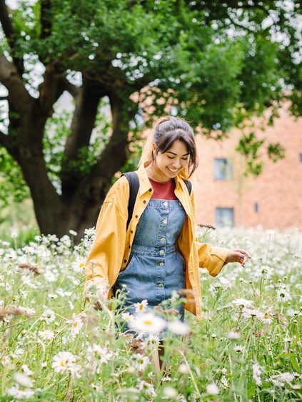 Student walking through flowery field