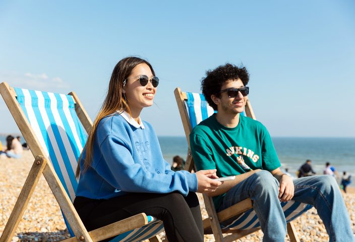 Two students sitting on sun loungers