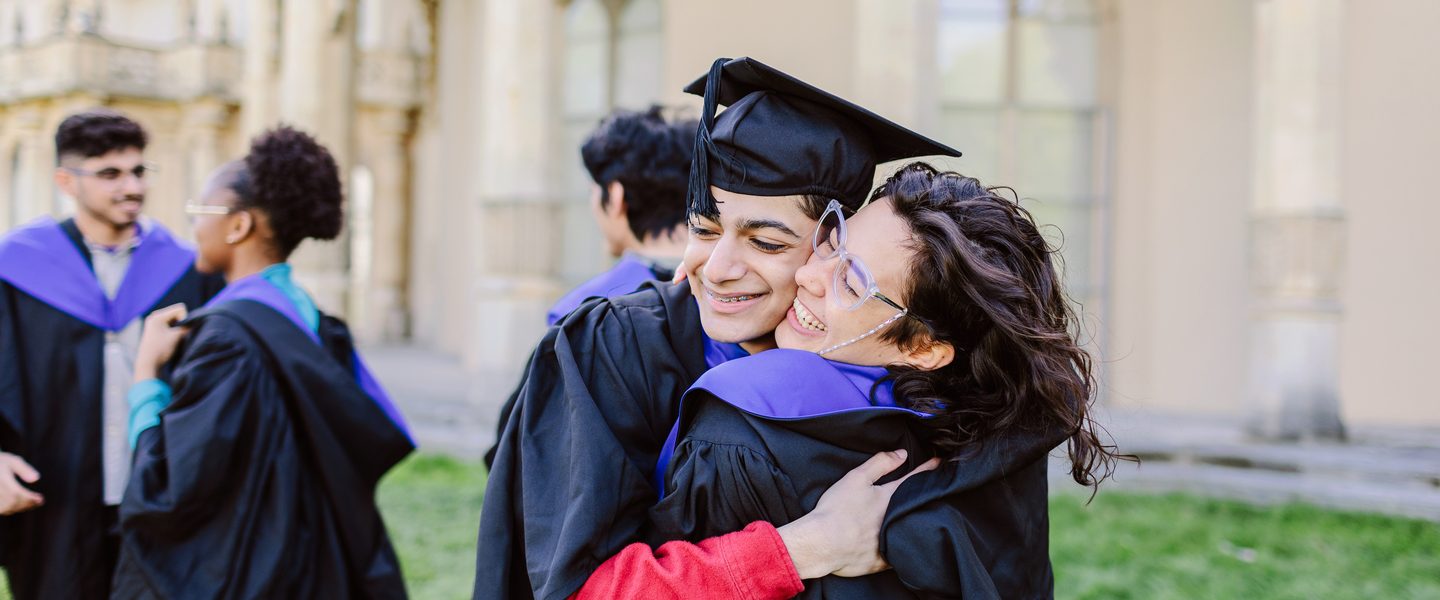 University of Brighton students hugging each other on their graduation day