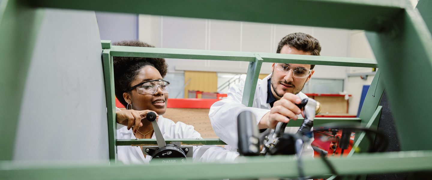 University of Nottingham students operating a machinery at the engineering lab
