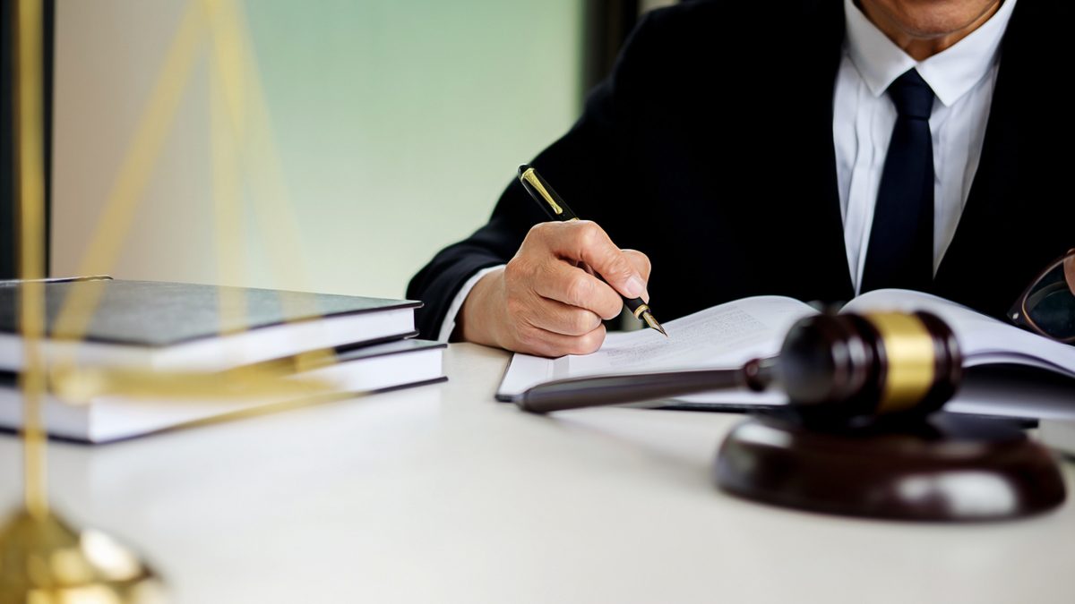 An attorney writing on a book