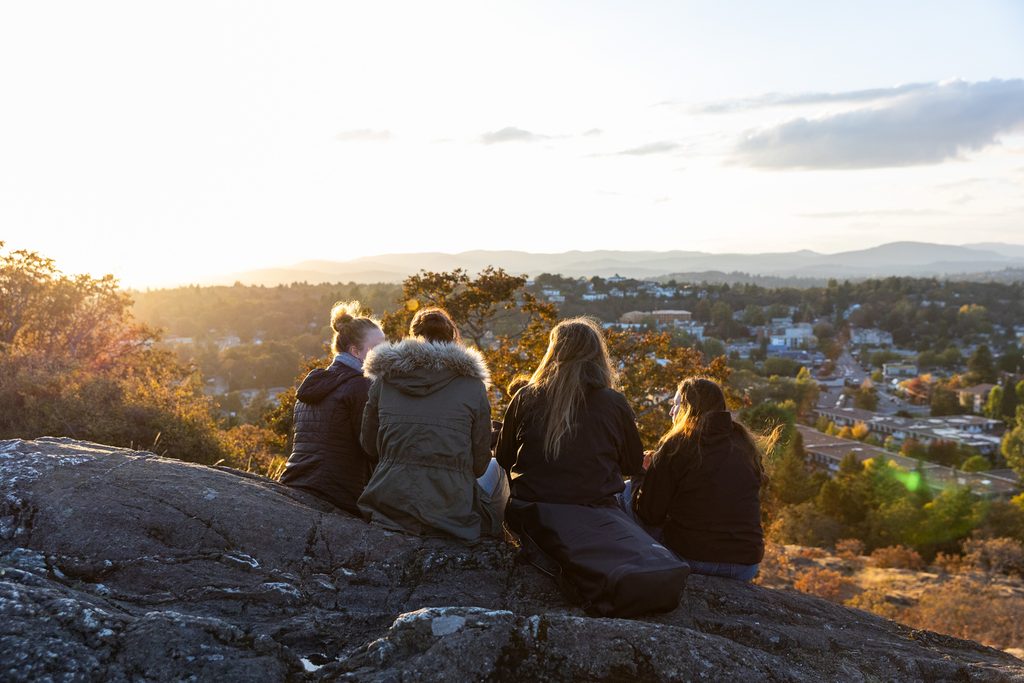 University of Victoria students sitting on the hill to see the view of the city