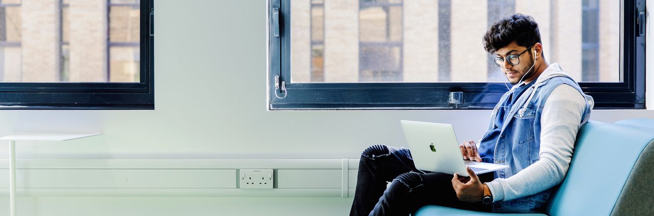 International student at Kaplan International College studying on his laptop