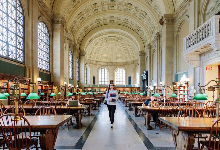 Student walking inside Boston Public Library