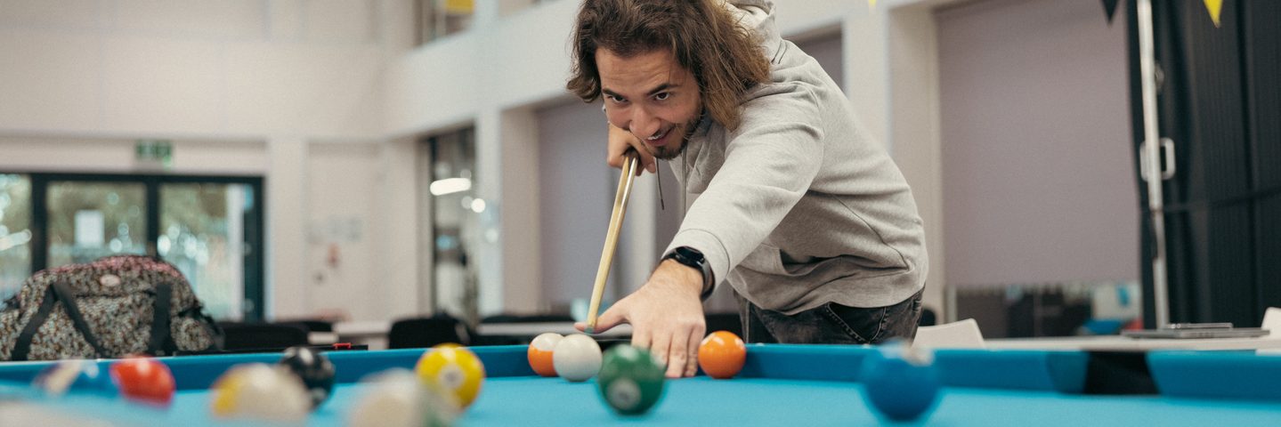 TEDI student playing pool on campus