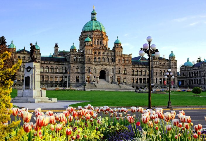 Historic legislative assembly building with a bed of spring tulips