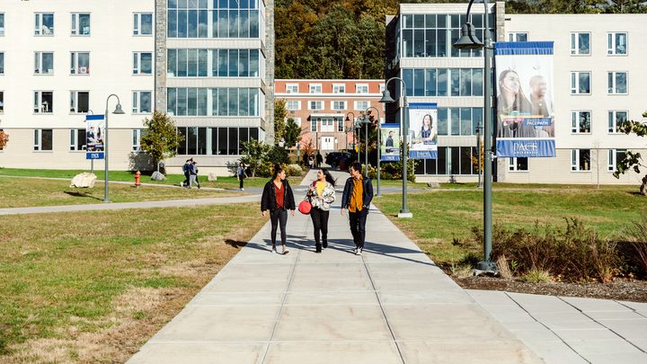 Three Pace University students socialising while walking on campus