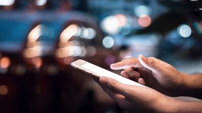 Close up image of hands using smartphone at night