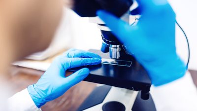 Scientist using a microscope to examine