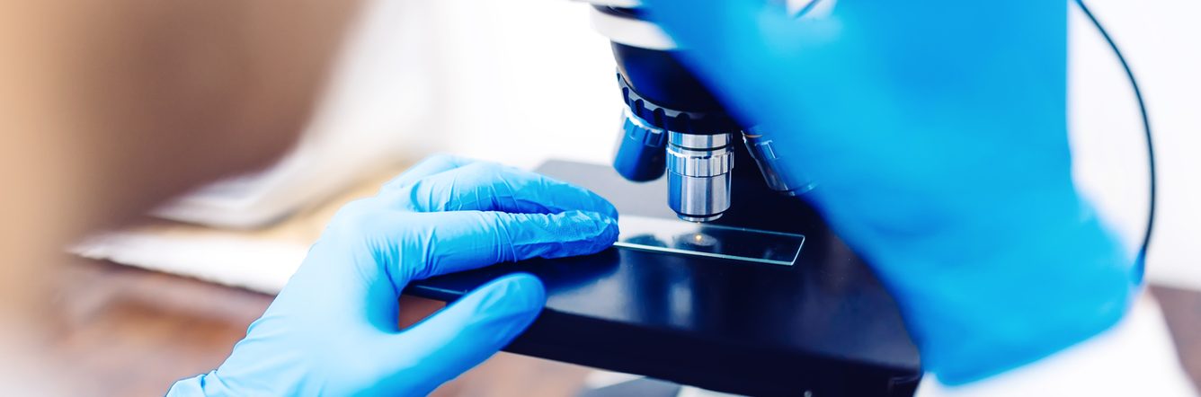 Scientist using a microscope to examine
